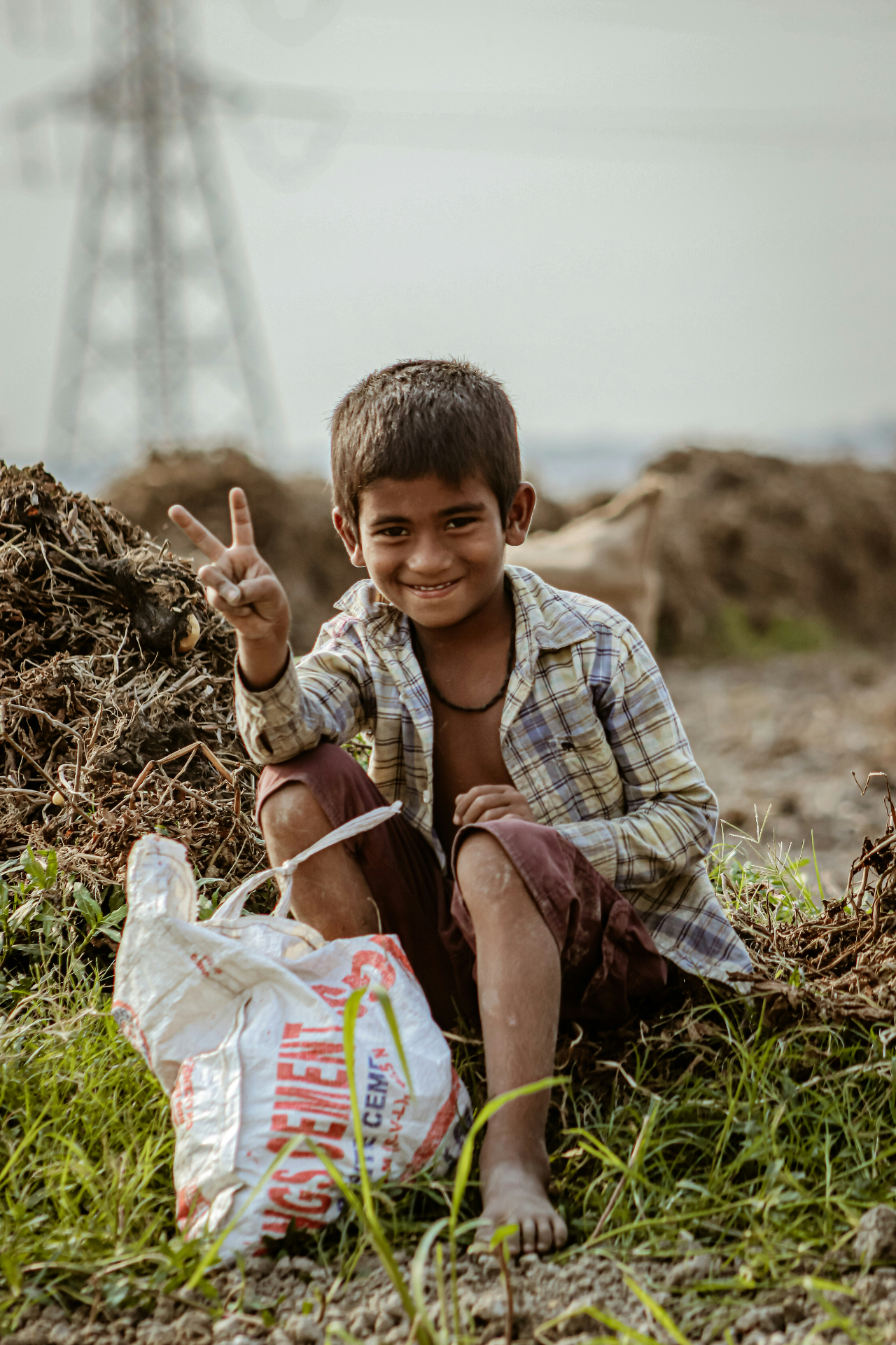 A smiling young boy from a rural Pakistani community giving a peace sign — one of the children Mayaar Foundation serves